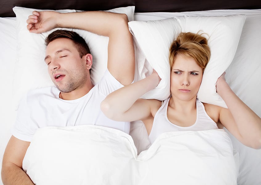 Snoring man and young woman. Couple sleeping in bed.