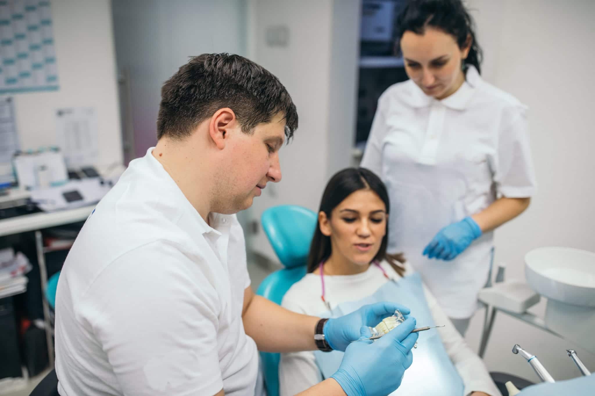 Doctor dentist showing to a woman patient dental prosthetics