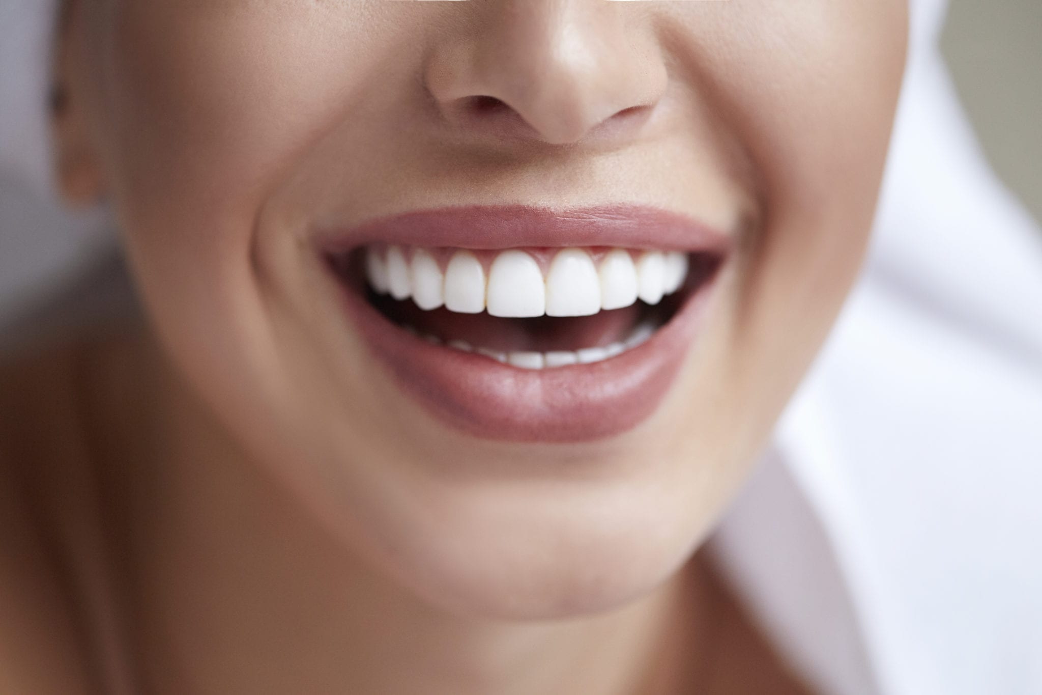 close up of bottom half of woman's face as she smiles widely