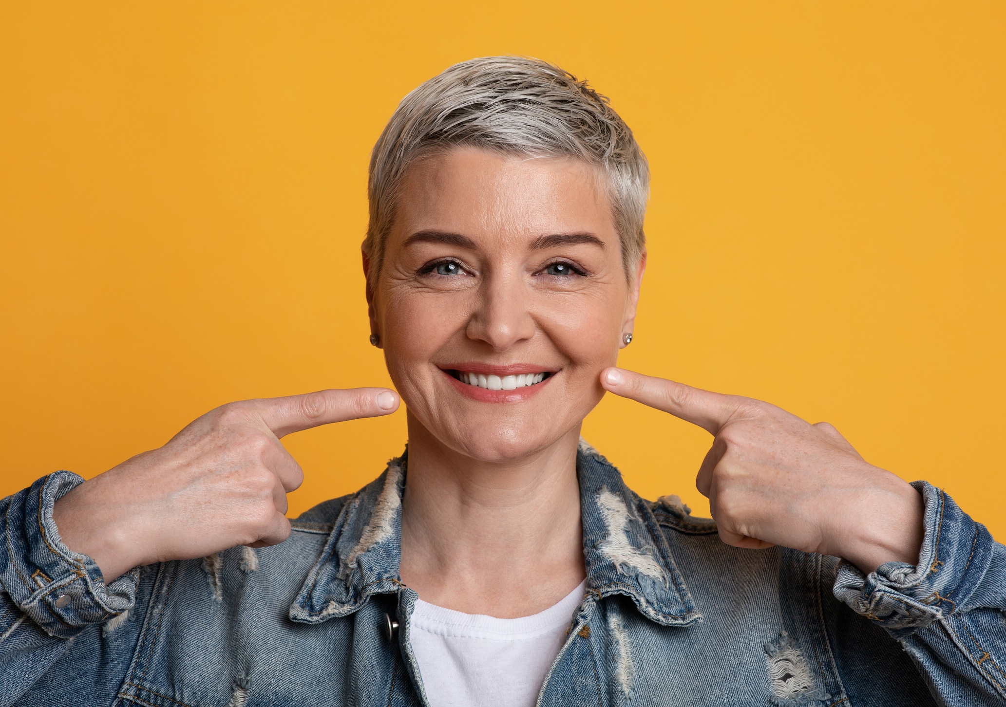 Woman pointing at her teeth while smiling