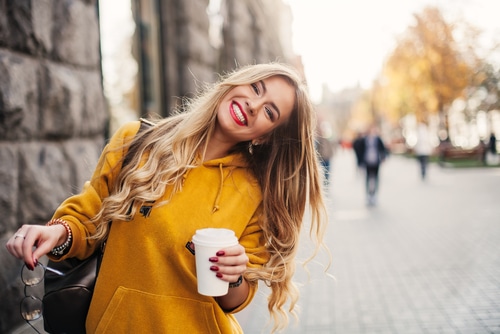 She holds coffee to go.