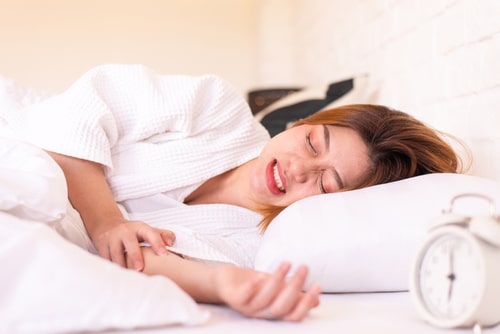 woman sleeping on the bed and grinding teeth